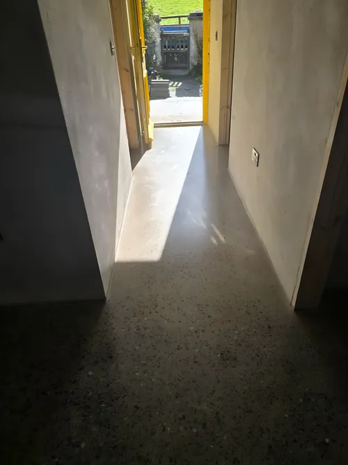 Polished concrete floor running the length of a hallway to the front door.