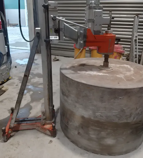 Large core lifted out of a concrete slab, with the drill rig still on its stand.