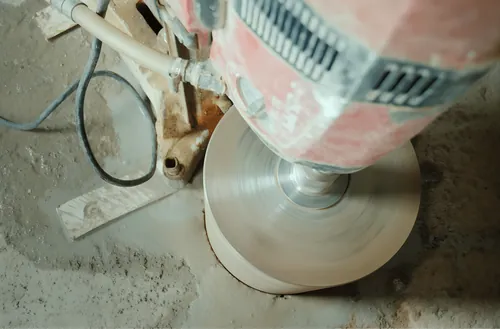 Diamond core bit going into a concrete floor slab, water-fed.
