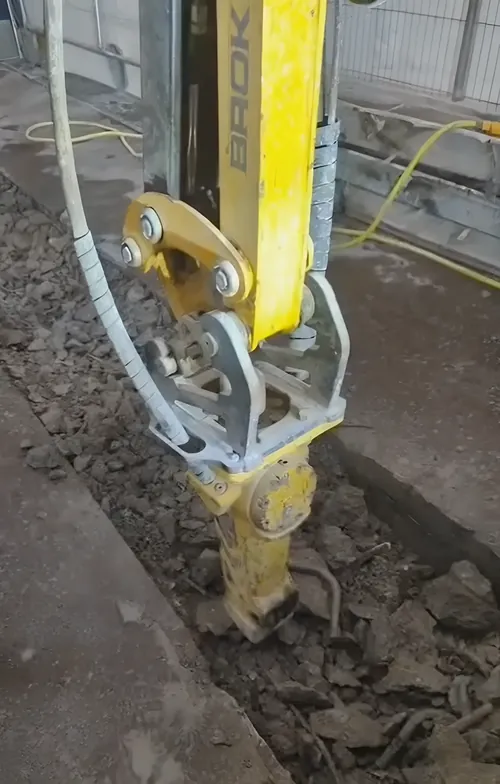 Remote-controlled demolition machine breaking out a concrete floor.
