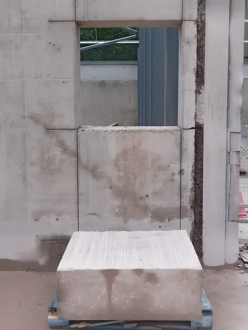 Window opening cut through a precast concrete wall, with the cut block lifted out onto a pallet.